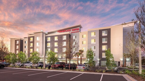 Een TownePlace Suites Marriott hotel met een parkeerplaats en bomen ervoor.