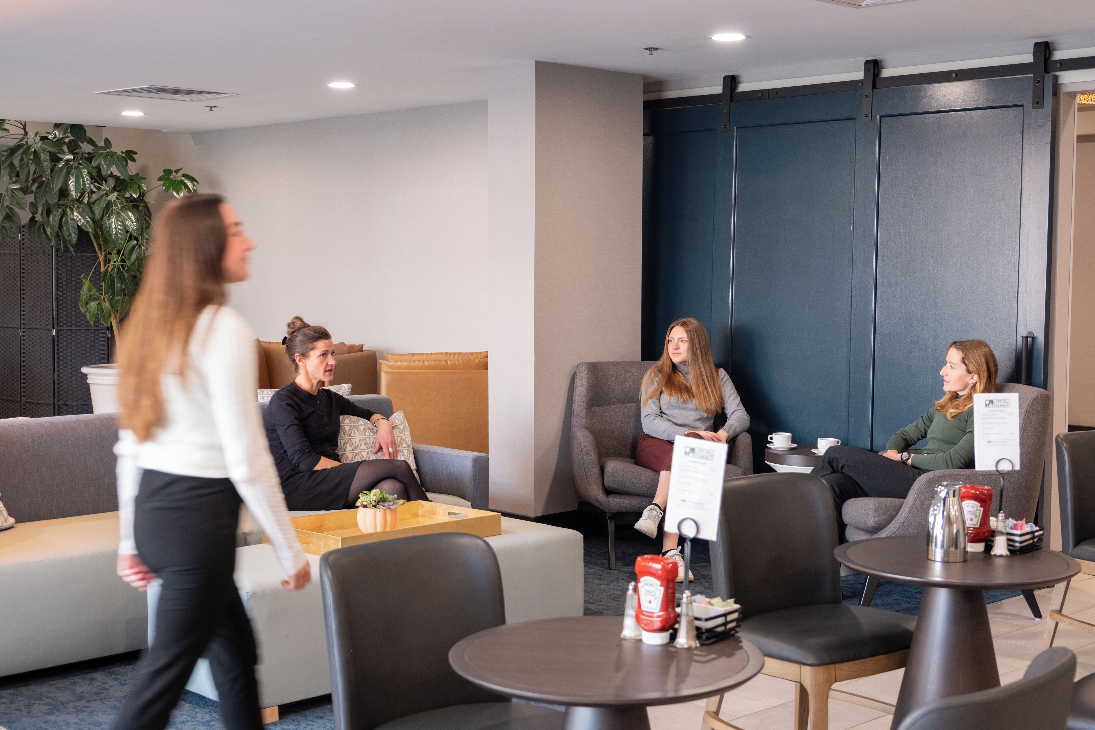 Ein stilvoller Lounge-Bereich mit Sitzgelegenheiten, Tischen und einer Kaffeestation.