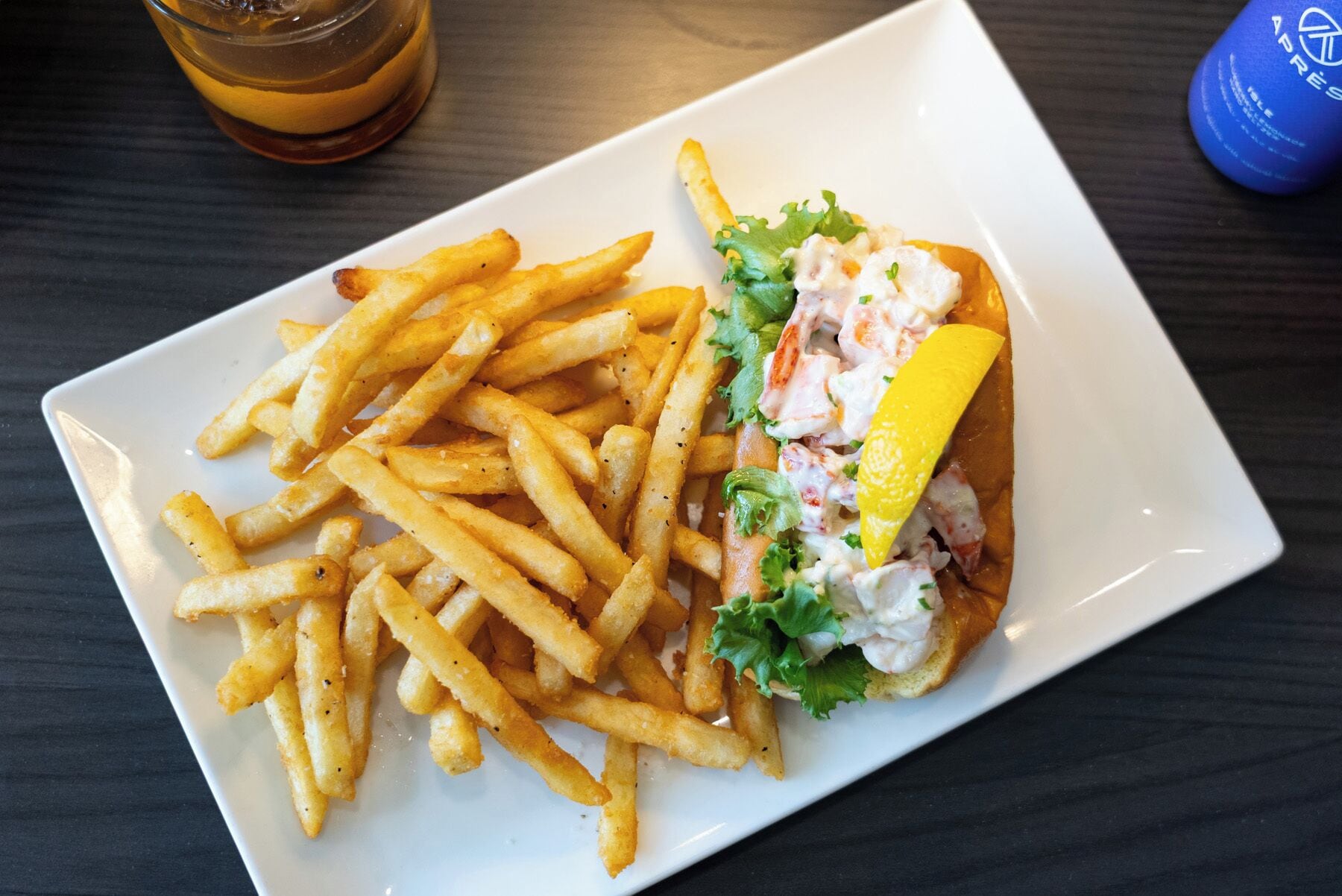 En tallrik med pommes frites och en smörgås, serverat på en vit tallrik.