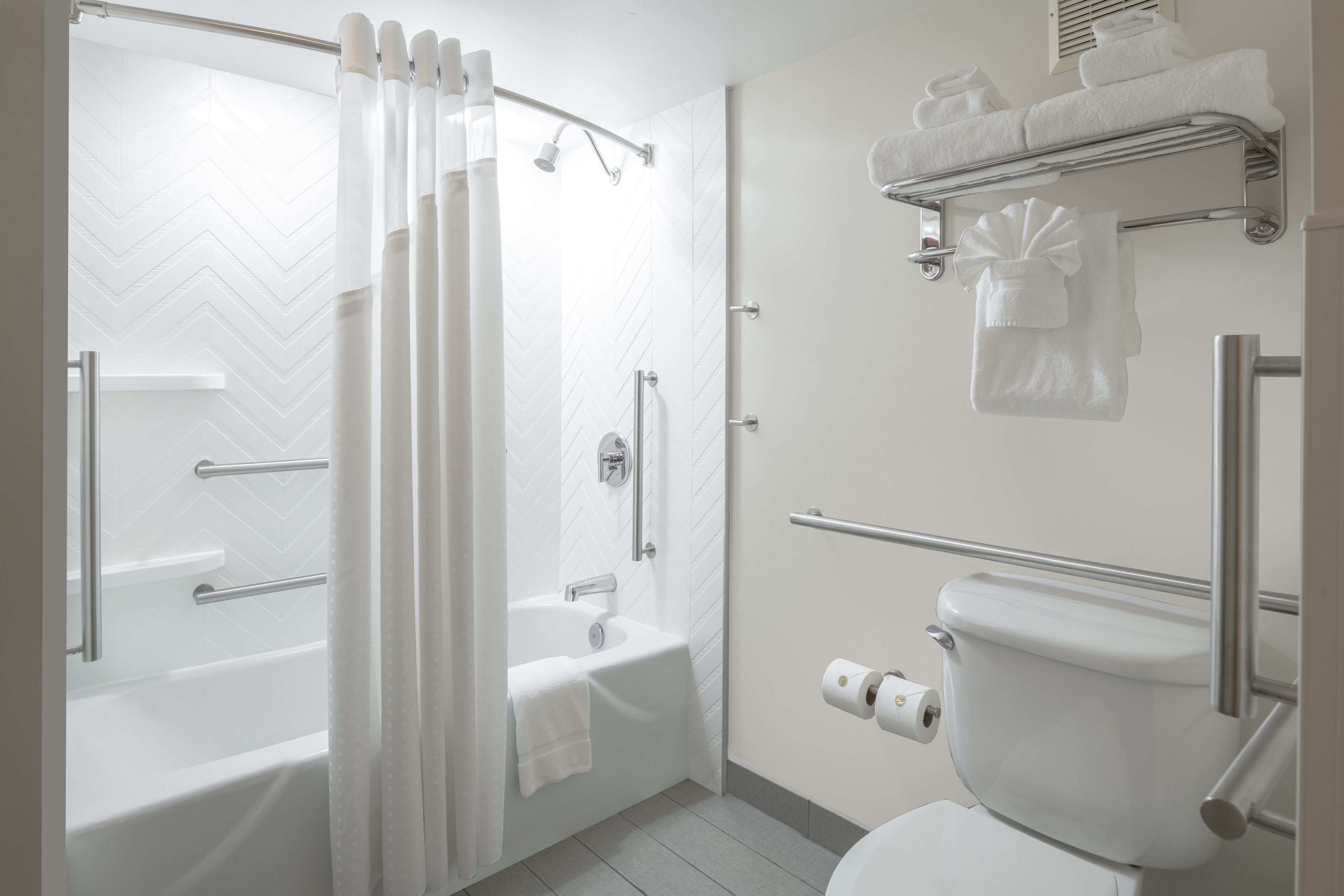 Een moderne badkamer met een douche, ligbad en toilet.