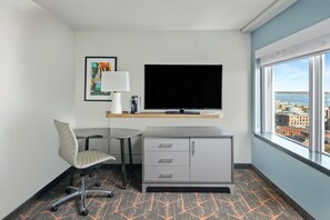 Enjoy a city view from the large window in this stylish room, featuring a flat-screen TV and a comfortable workspace.