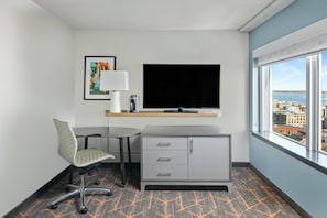 Enjoy a city view from the large window in this stylish room, featuring a flat-screen TV and a comfortable workspace.