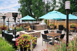 An outdoor patio with seating, a fire pit, and umbrellas. - Residence Inn By Marriott Boulder (Boulder)