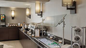 A buffet area with a coffee machine, ice bins, and a beverage dispenser.