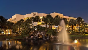 Un hôtel Sheraton doté d’une fontaine, de palmiers et d’un bassin.