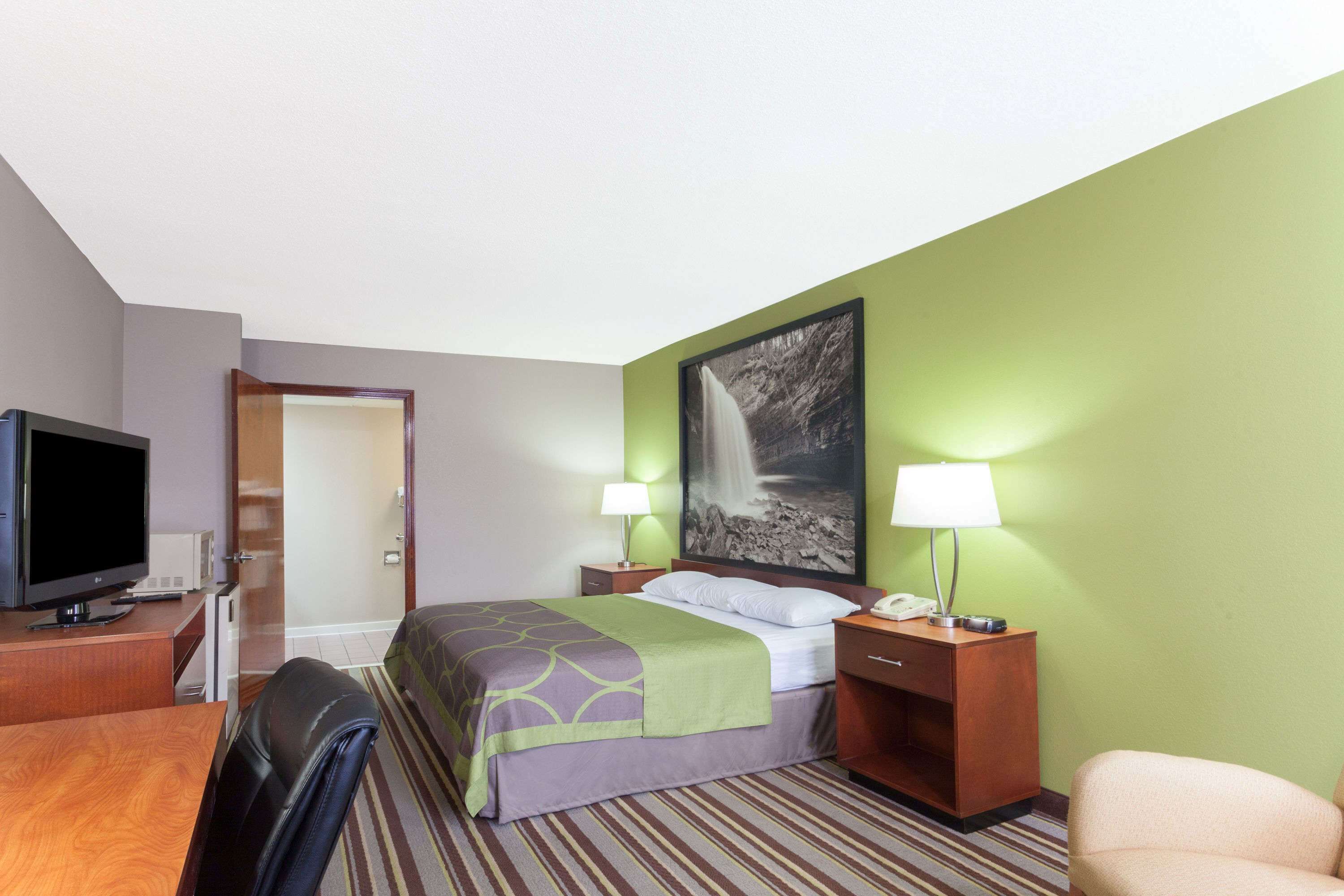 Une chambre d’hôtel équipée d’un lit, d’une télévision, d’un bureau et d’une chaise.