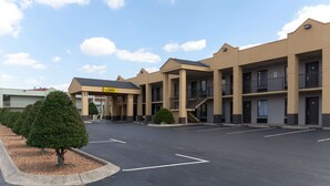 A motel with a central entrance, multiple floors, and a parking lot.