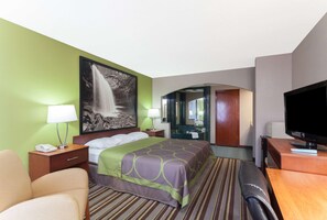 A hotel room with a bed, a desk, a TV, a mirror, and a bathroom visible through an archway. - Super 8 by Wyndham Clarksville Northeast (Clarksville)
