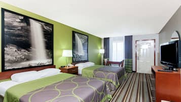 Habitación de hotel con dos camas, televisor, escritorio y puerta al baño.
