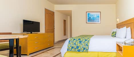 A hotel room with a bed, a desk, a television, and a wardrobe.
