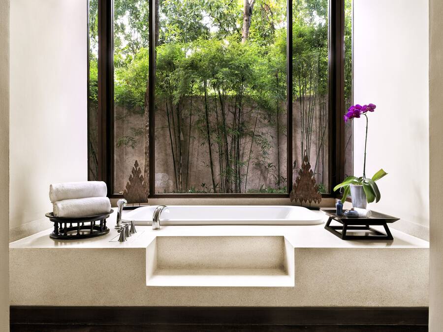 Ein Badezimmer mit großem Fenster, einem Waschbecken und einem Spiegel.