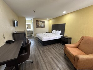 Une chambre d’hôtel avec un lit, un bureau, une chaise et un canapé.