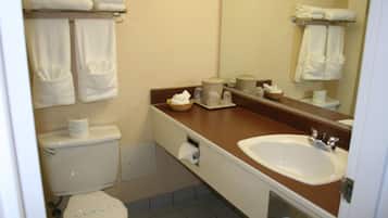 Un baño con inodoro, lavamanos y toallas.