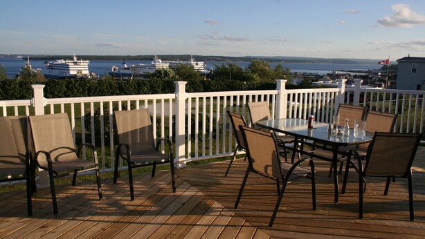 Eine Terrasse mit Sitzgelegenheit und Blick auf das Wasser.