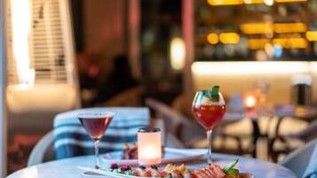 A dining table with two cocktails and a seafood platter in a well-lit indoor setting.