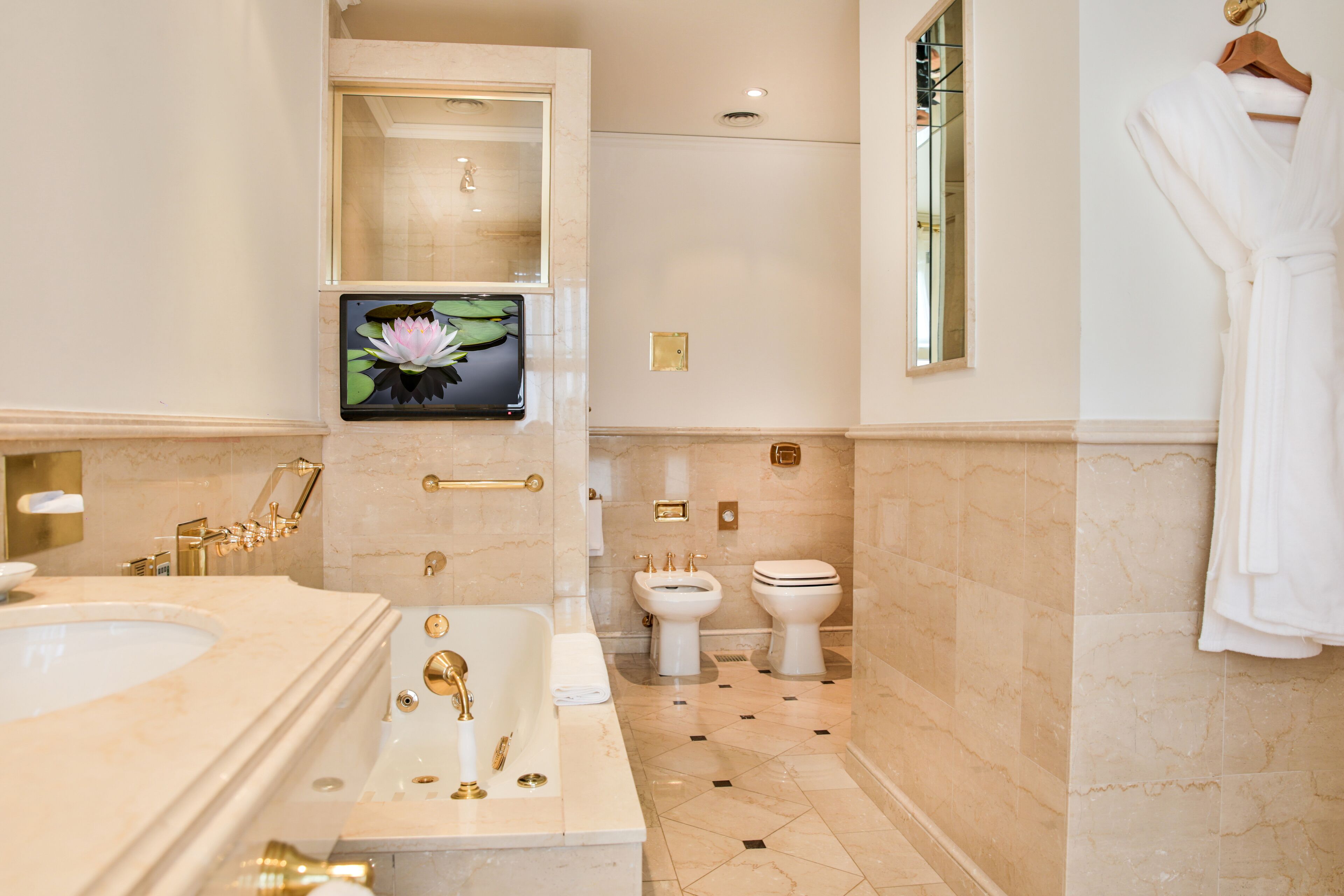 Un baño moderno con bañera, lavabo, inodoro y espejo.