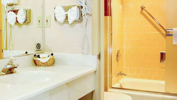 A bathroom with two sinks, a mirror, a towel rack, and a shower area. - Ruby Inn (Bridgeport)
