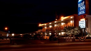 A Ruby Inn building with a sign, parking lot, and several cars.