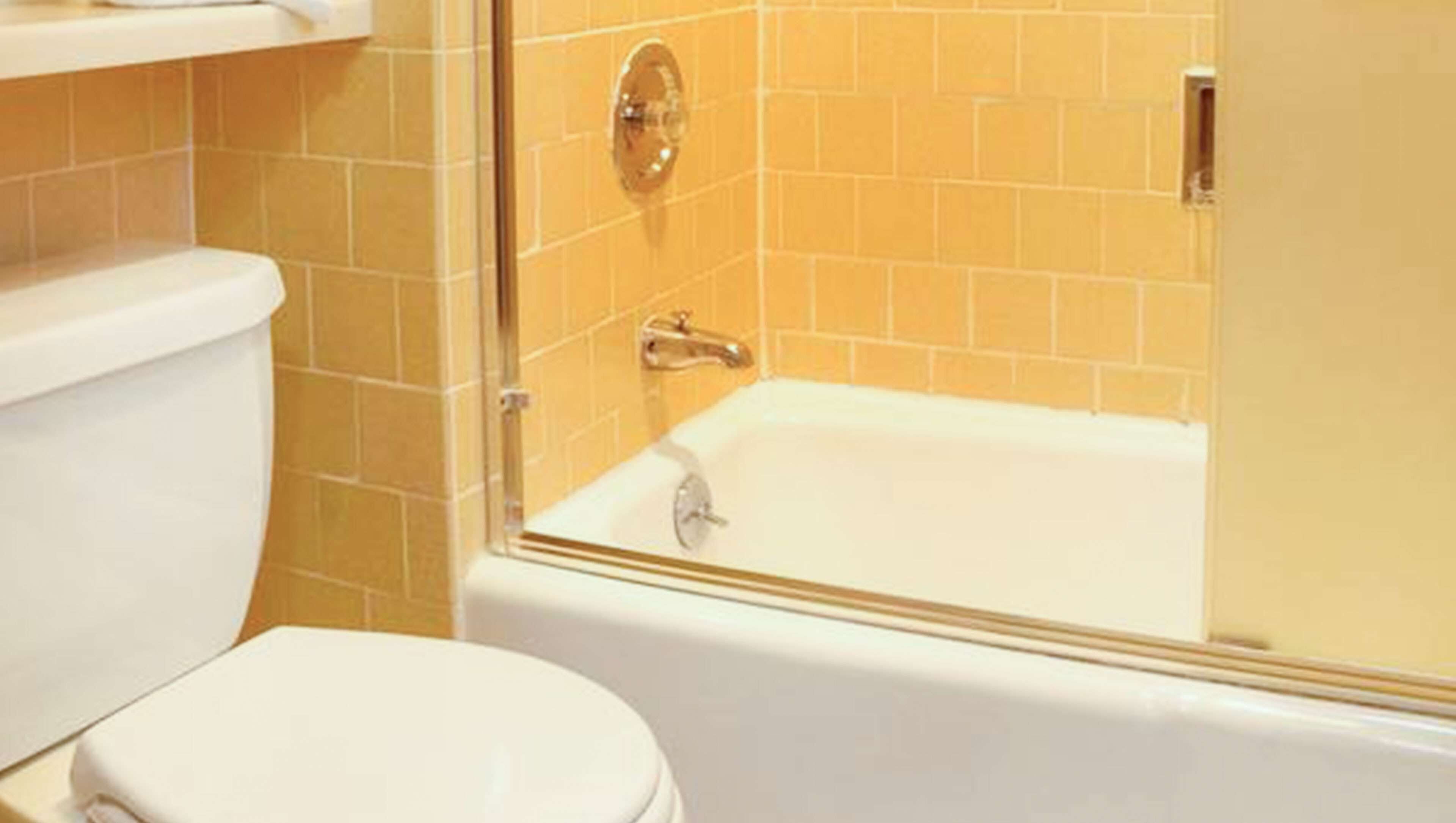 A bathroom with a toilet, a bathtub, and a shower enclosure.