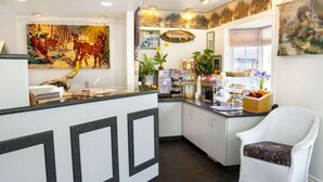 A kitchen area with a counter, a coffee machine, and a wicker chair.