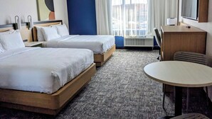 A hotel room with two beds, a desk, a chair, a TV, and a large window with curtains. - Spark by Hilton Montreal Brossard (Brossard)