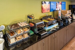 Un bufé de desayuno con diferentes opciones de comida y una estación de café.