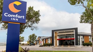 A Comfort Inn hotel with a modern facade, a prominent sign, and a well-maintained lawn. - Comfort Inn Winnipeg Airport (Winnipeg)
