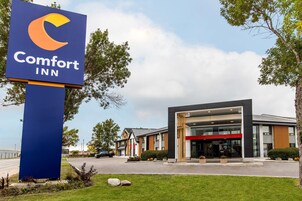 Un hotel Comfort Inn con fachada moderna, un letrero llamativo y un césped bien cuidado.