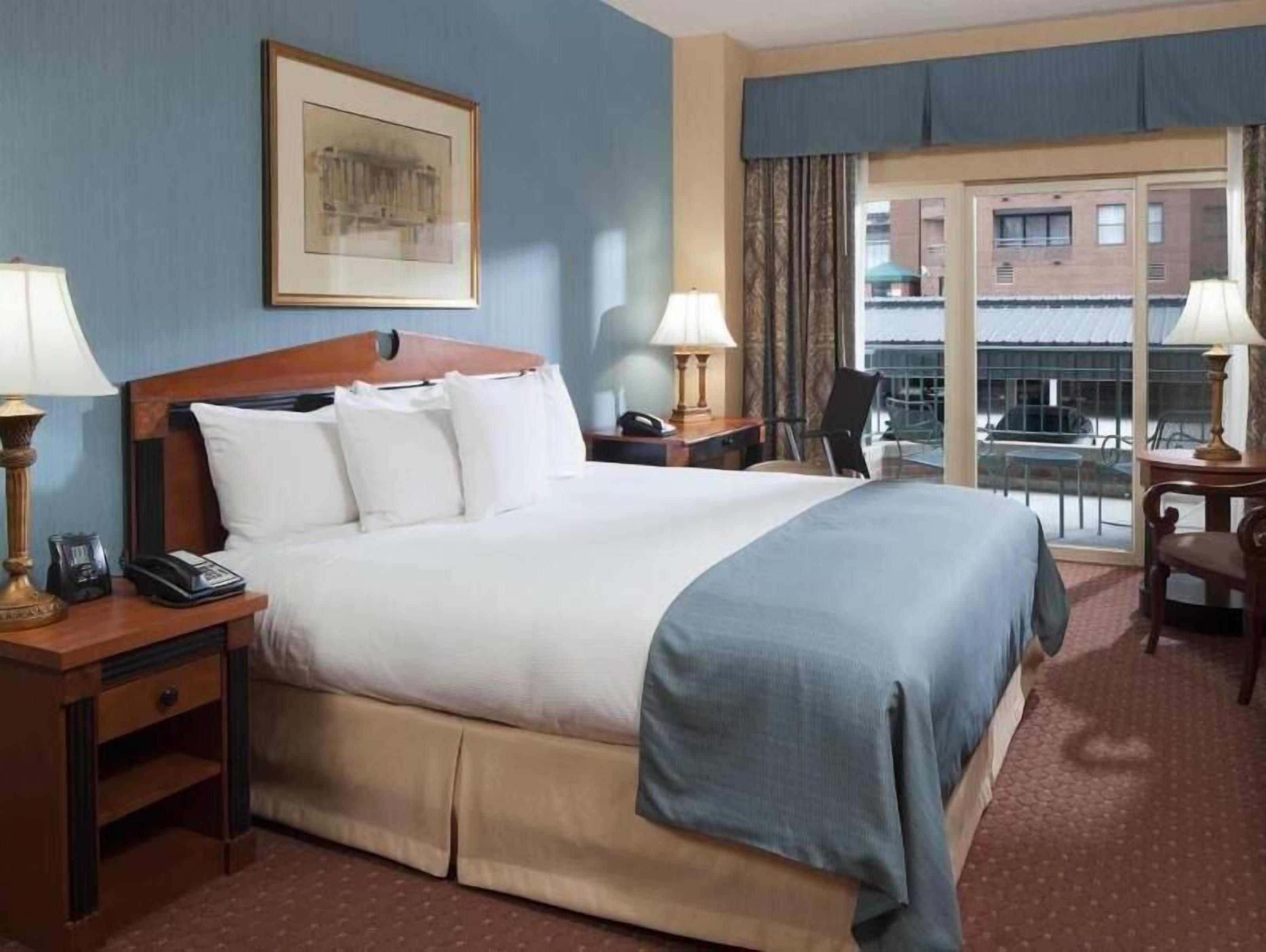 أغطية فراش متميزة وخزنة داخل الغرفة ومكتب وستائر تعتيم