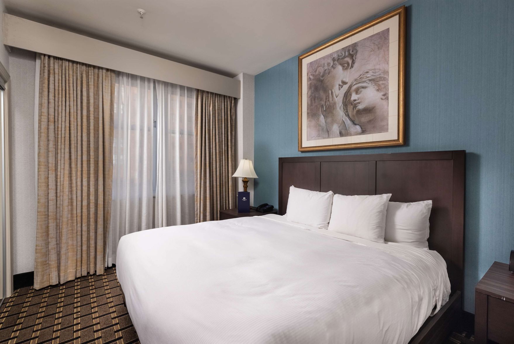 أغطية فراش متميزة وخزنة داخل الغرفة ومكتب وستائر تعتيم