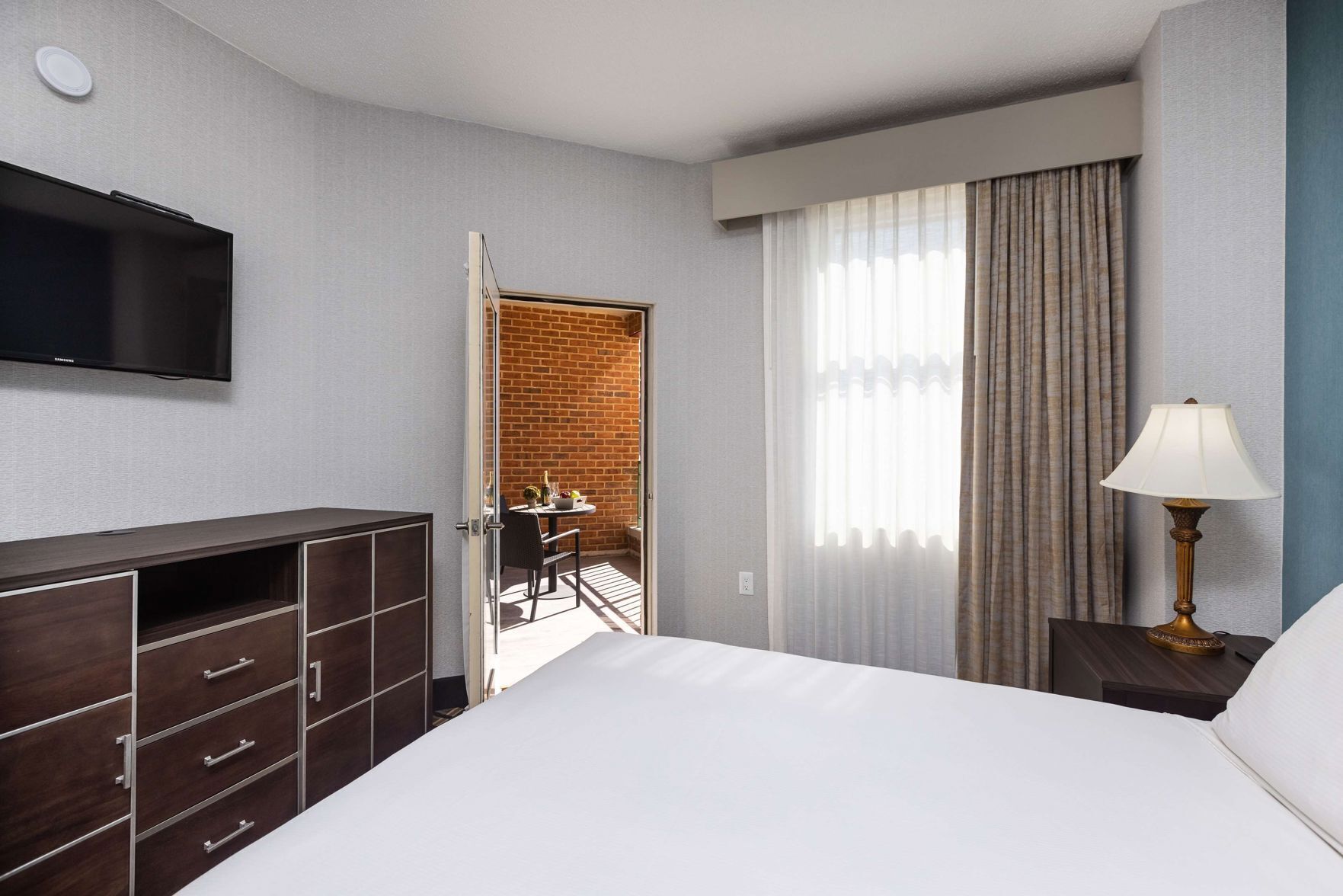 أغطية فراش متميزة وخزنة داخل الغرفة ومكتب وستائر تعتيم