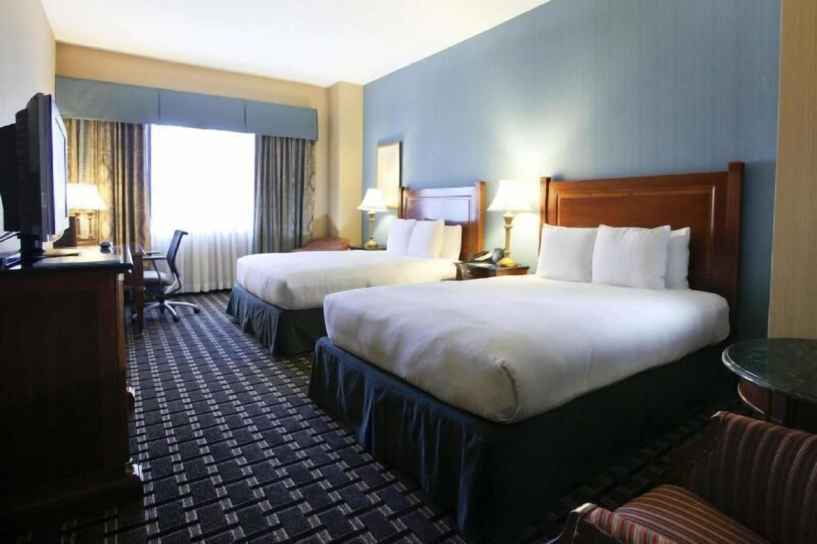 أغطية فراش متميزة وخزنة داخل الغرفة ومكتب وستائر تعتيم