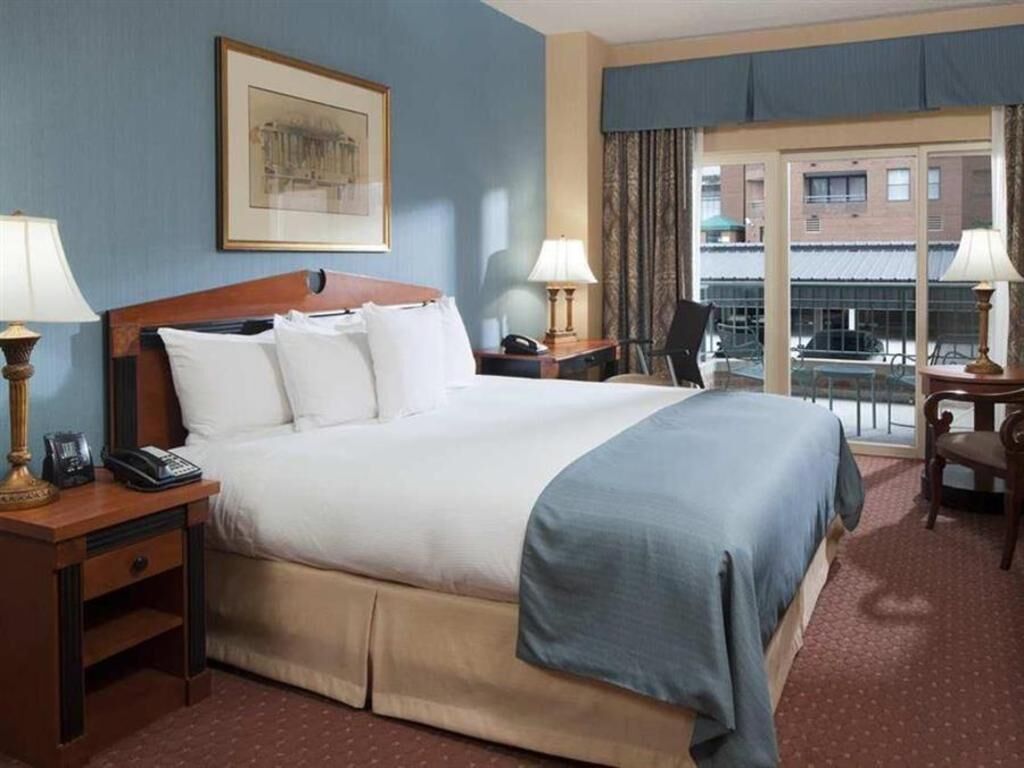 أغطية فراش متميزة وخزنة داخل الغرفة ومكتب وستائر تعتيم