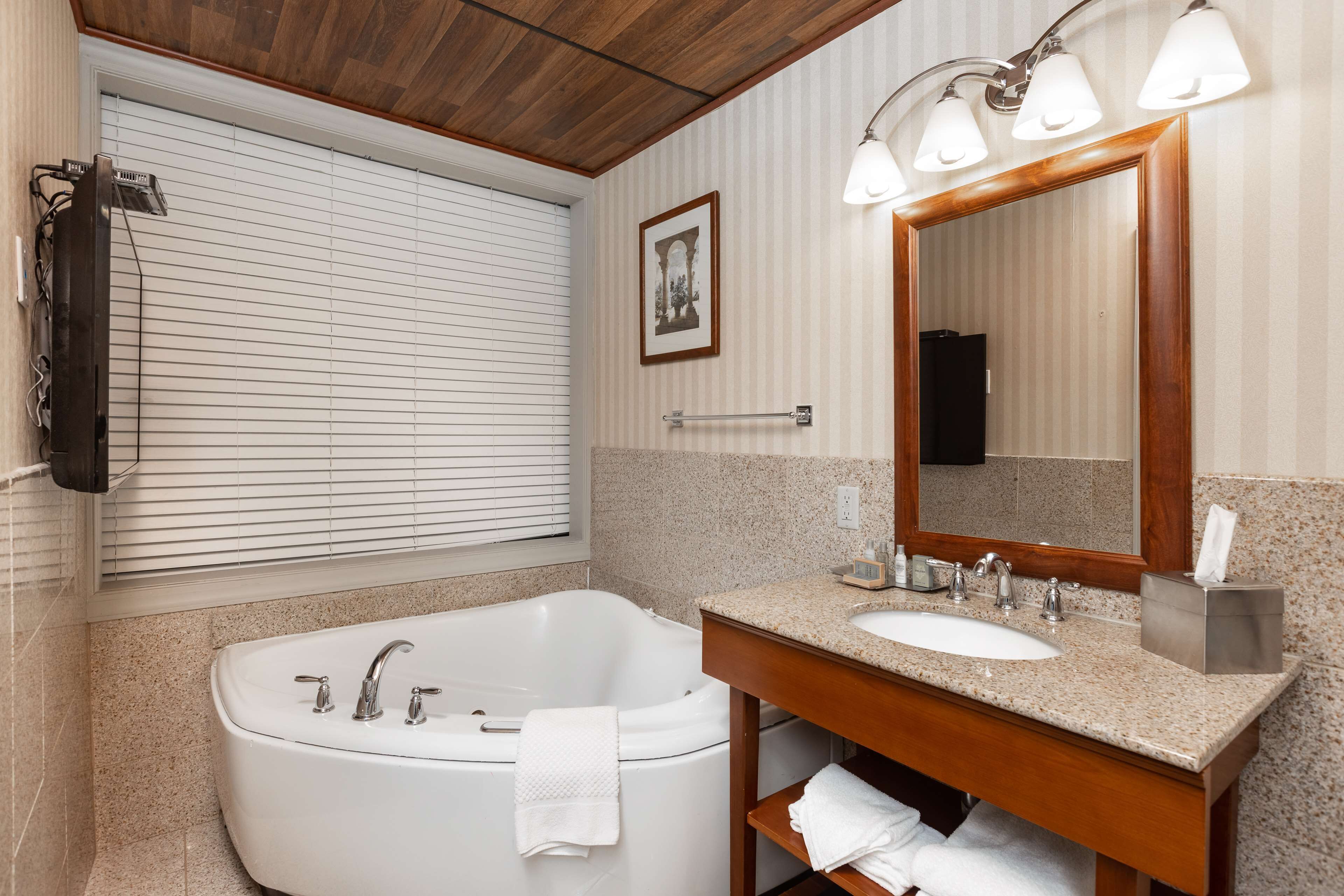 Une salle de bain moderne avec une baignoire sur pieds, un meuble-lavabo et un grand miroir.