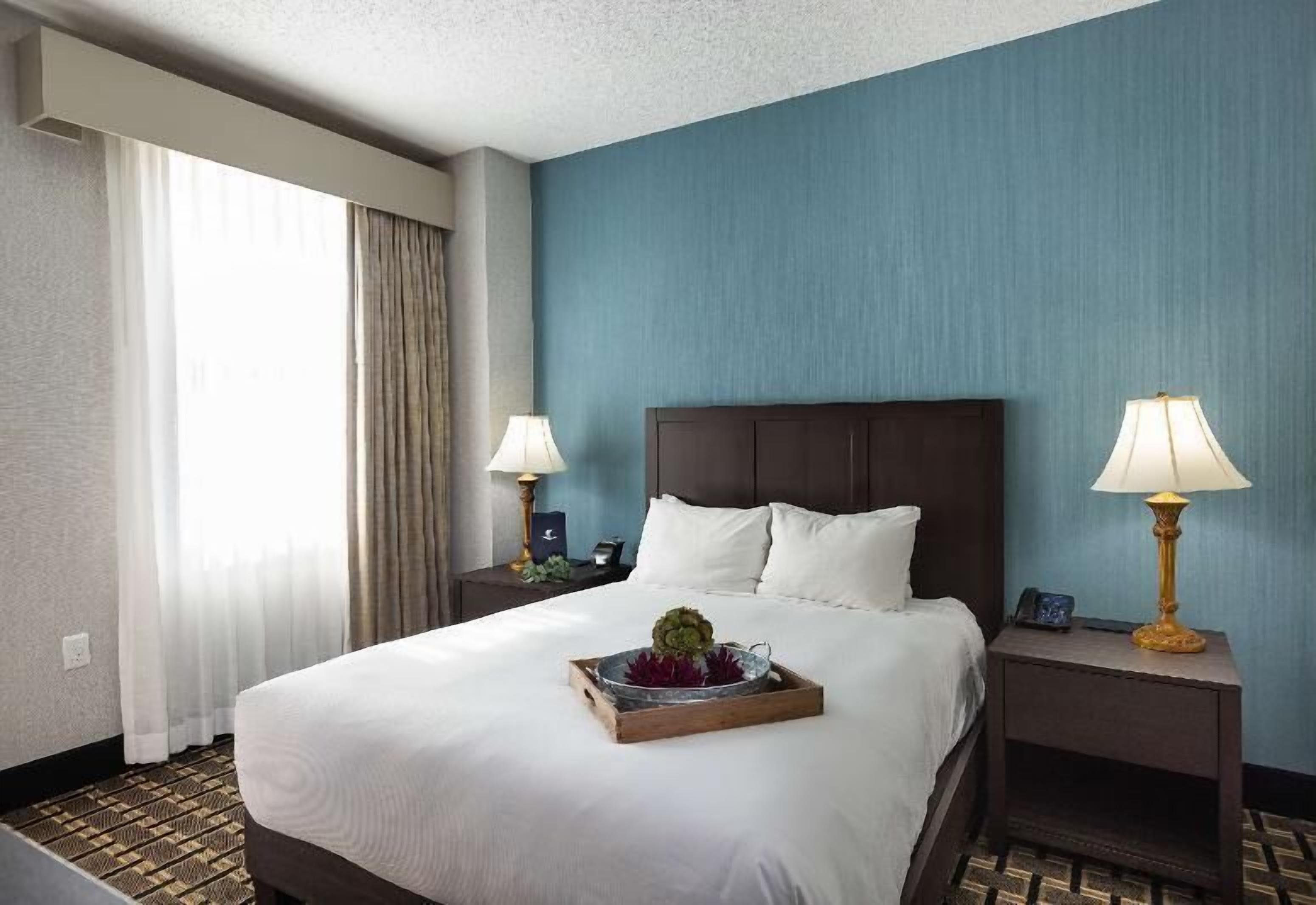 أغطية فراش متميزة وخزنة داخل الغرفة ومكتب وستائر تعتيم