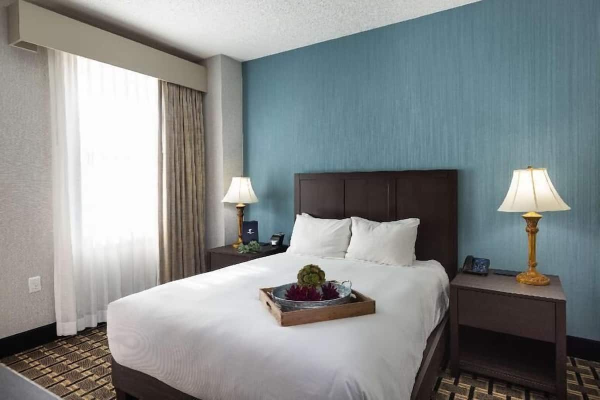 أغطية فراش متميزة وخزنة داخل الغرفة ومكتب وستائر تعتيم