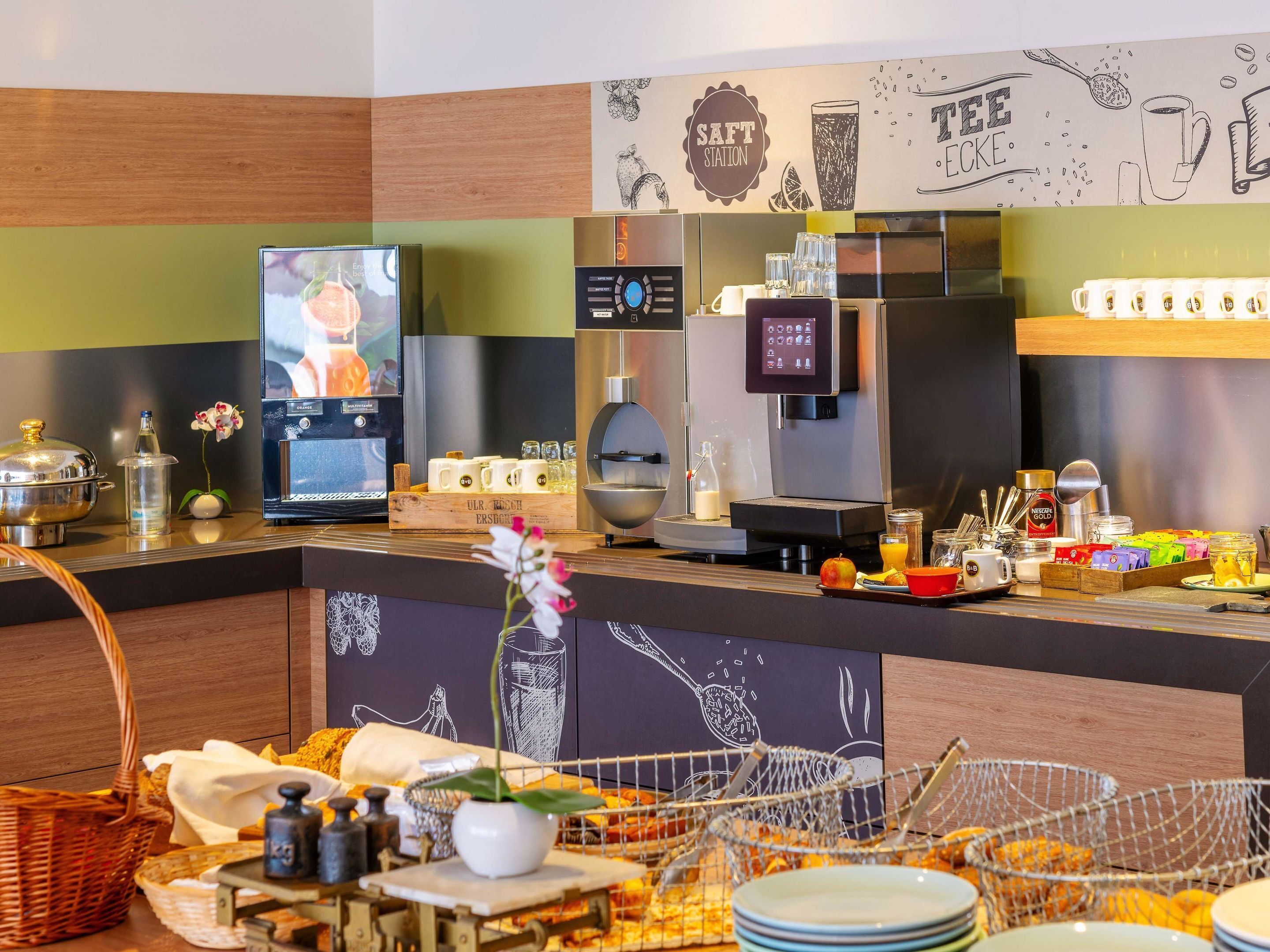 A breakfast bar with coffee machines, a TV, and a variety of food items.