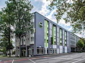 A modern hotel building with a green and grey facade, large windows, and a visible entrance. - B&B Hotel Aachen-Hbf (Aachen)