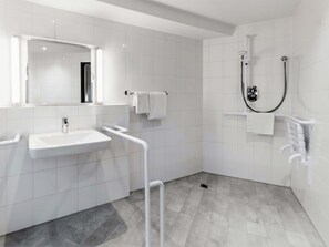 A modern bathroom with a white sink, mirror, and shower. - B&B Hotel Aachen-Hbf (Aachen)