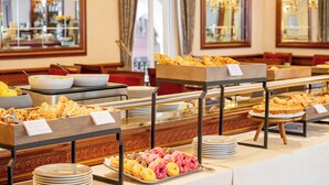 Un bufé con diferentes opciones de comida y un espejo que refleja el interior de la sala.