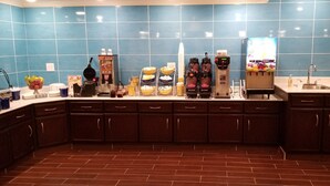 A kitchen with blue tiles, a coffee machine, and a sink.