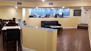 A restaurant with booths and tables, a counter with a blue tiled backsplash, and a door in the background.