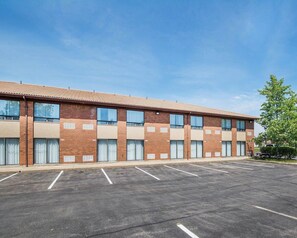 A multi-story building with a parking lot in front.