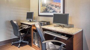 A hotel room with a desk, two monitors, a keyboard, and two chairs. - Comfort Inn (Bathurst)