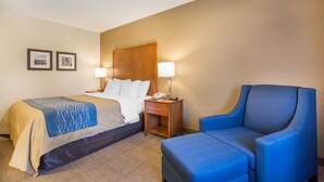A hotel room with a bed, two bedside tables, a chair, and two framed pictures on the wall. - Comfort Inn (Bathurst)