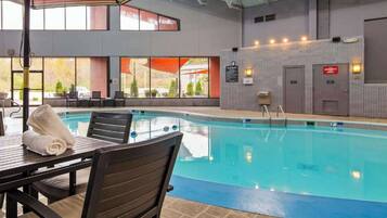 Relax by the pool surrounded by lounge chairs and a table.