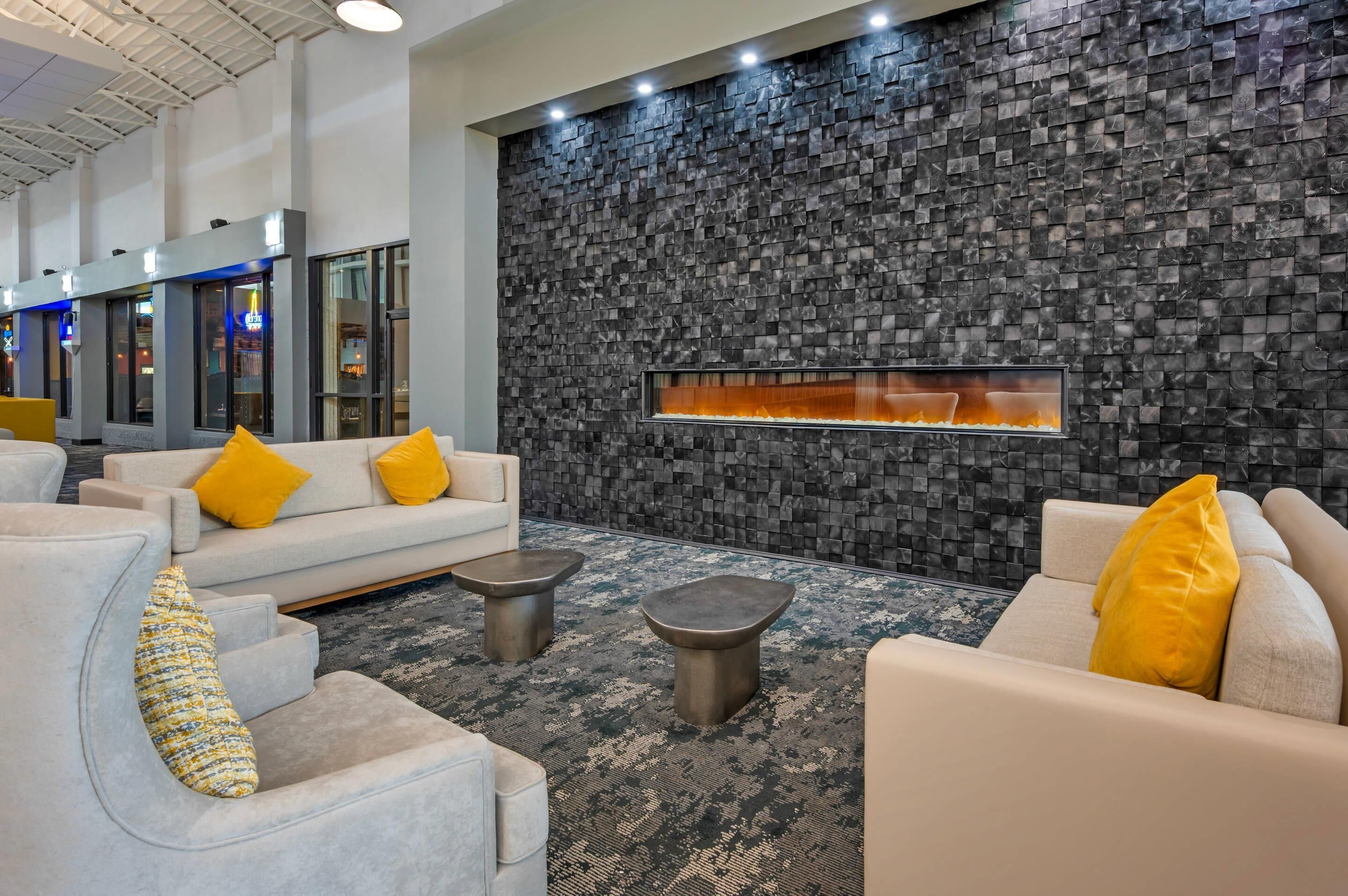 Um lobby moderno com parede de pedra, área de estar e lareira.