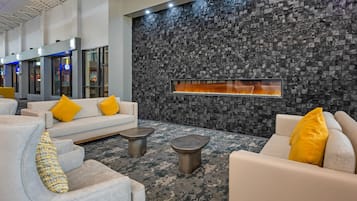 Um lobby moderno com parede de pedra, área de estar e lareira.