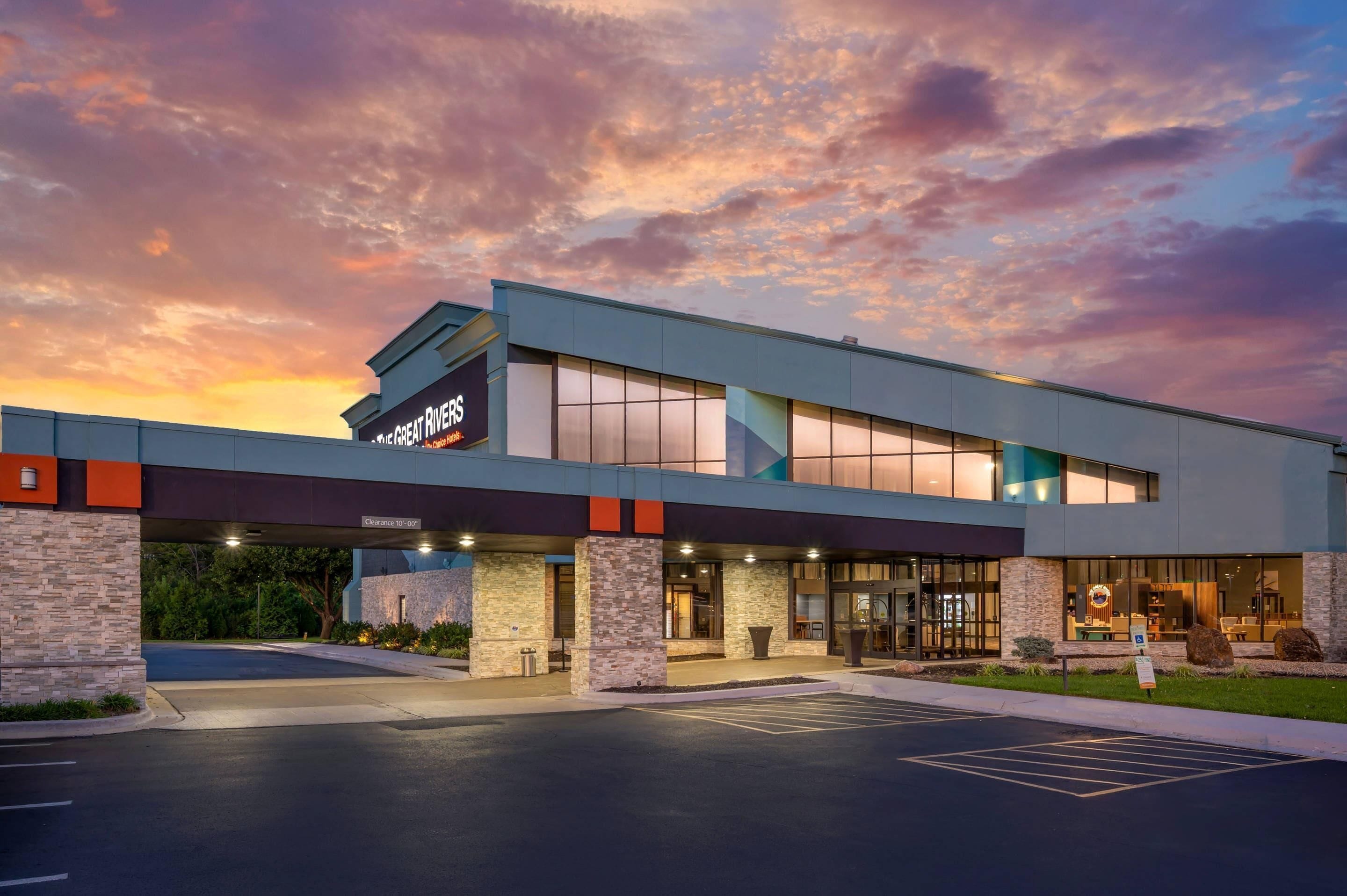A hotel with a modern design, featuring a large glass facade and a covered entrance.