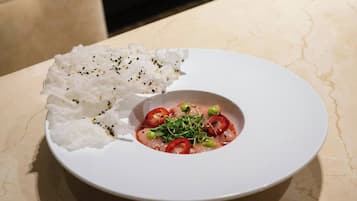 A white plate with a dish of food on a marble table.